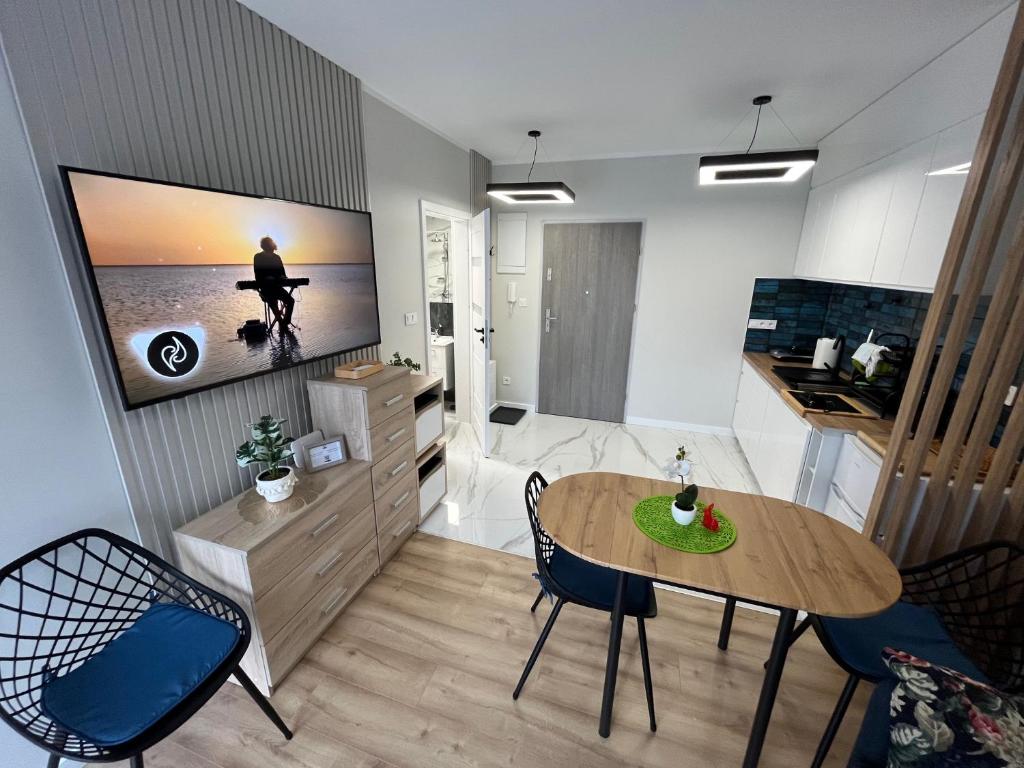 a living room with a table and chairs and a television at Apartament Calisia II in Kalisz