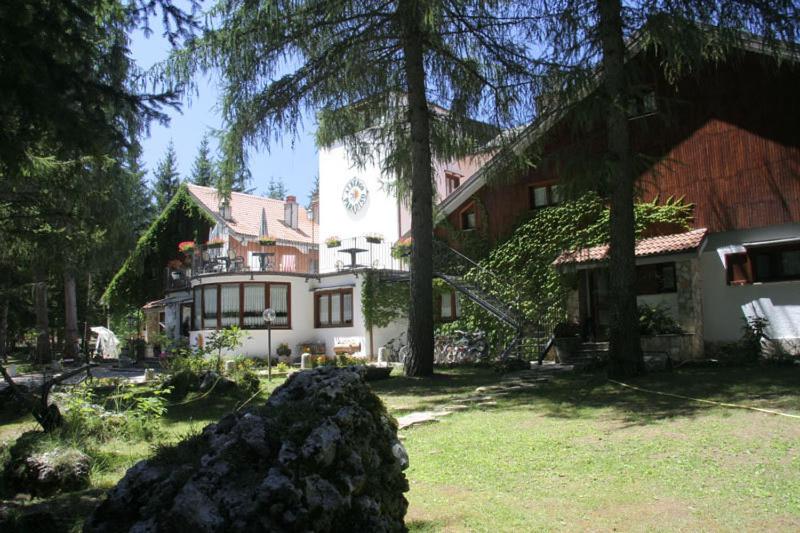 a large white house with trees in front of it at LH Albergo Il Paradiso in Pescasseroli