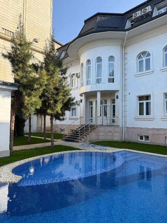 a large building with a blue pool in front of it at ART Dream Hotel in Tashkent