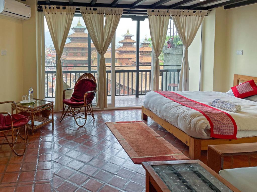 a bedroom with a bed and a balcony at Lalit Heritage Home in Pātan