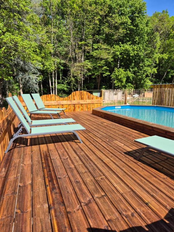 a wooden deck with chairs next to a swimming pool at La Cabane du Porteau in Saint-Georges-sur-Cher