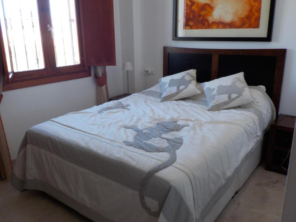 1 dormitorio con 1 cama grande con sábanas blancas en Navigolf, en La Cala de Mijas