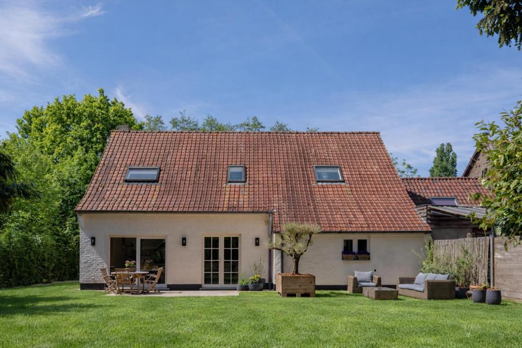 a white house with a red roof at Boutique Stay with Bath & Garden near Ghent in Sint-Martens-Latem