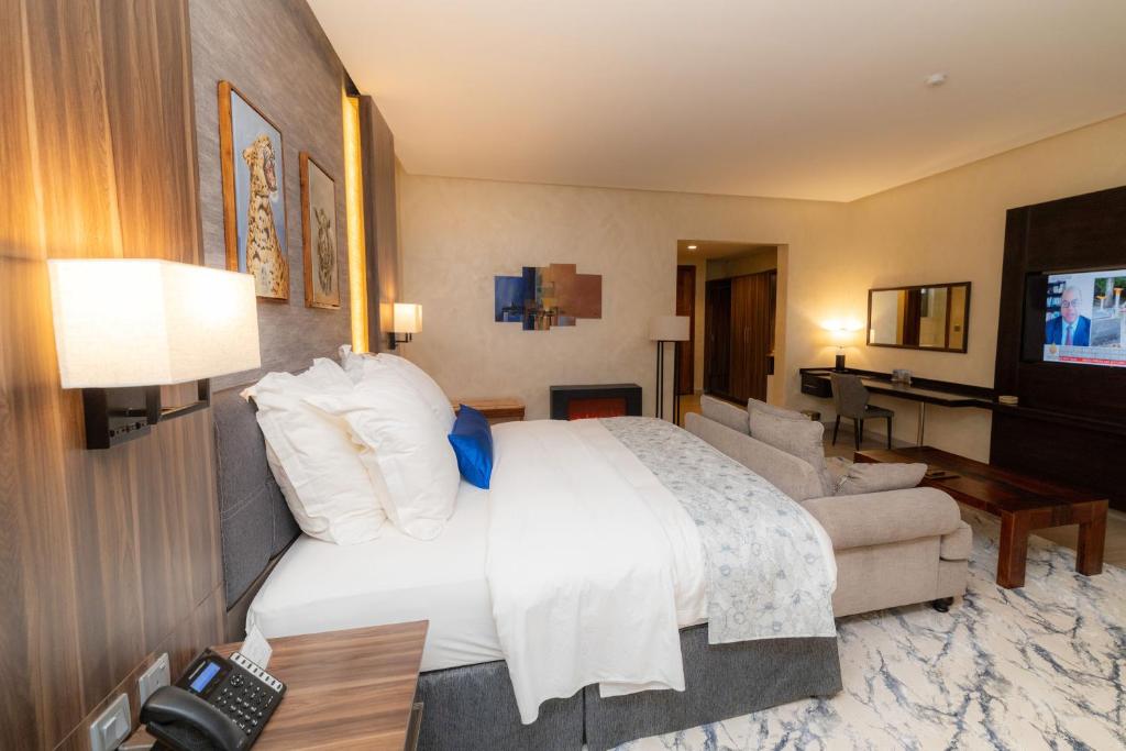 a bedroom with a large bed and a living room at Virunga Inn Resort & Spa in Kinigi