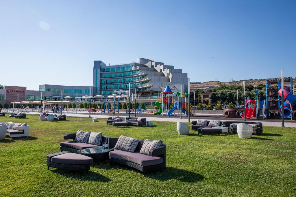 een park met banken en stoelen op het gras bij Ramada by Wyndham Baku in Baku
