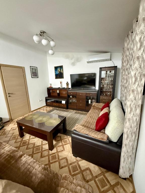 a living room with a couch and a tv at King Apartment in Sutomore
