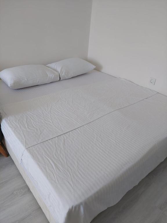 a white bed with two pillows on top of it at Alaçatı evi in Alaçatı