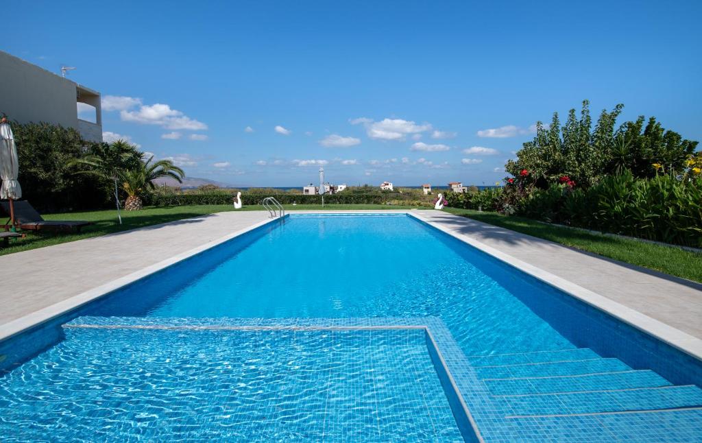 a large swimming pool with blue water at Socrates Holidays Apt 3 with Pool near the Beach in Kamisianá