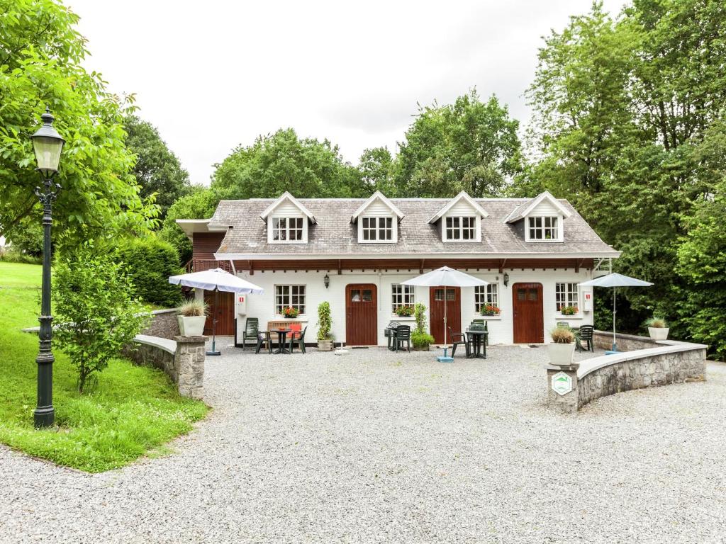 a house with a patio with tables and umbrellas at Peaceful Bohon Apartment in Barvaux