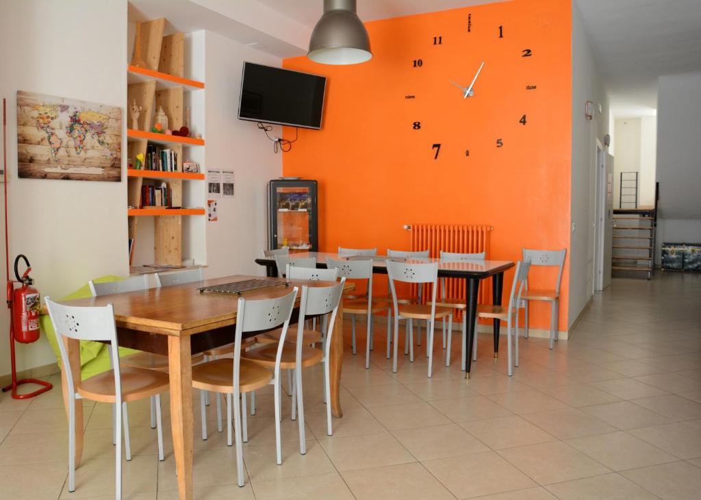 a dining room with a table and chairs and a clock at The Rock Hostel in Matera
