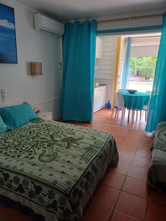 a bedroom with a bed and a table and blue curtains at Our dream in blue in Sèze