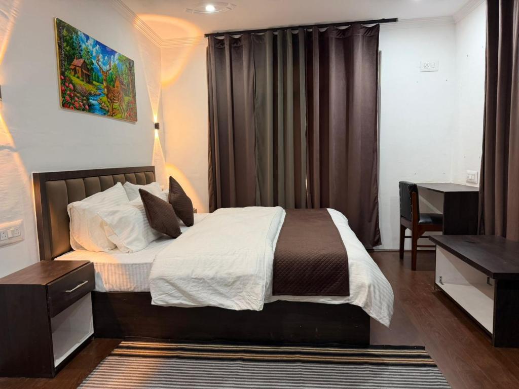 a bedroom with a large bed and a desk at FarahBakshResidency in Srinagar