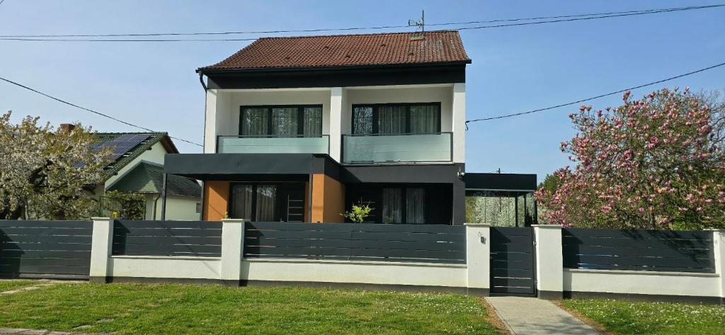 a house with a white fence in front of it at Barcs Thermal Apartments in Barcs