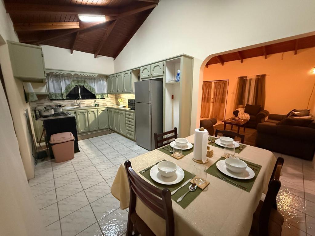 a kitchen and a dining room with a table and chairs at The Corinth House in Corinthe