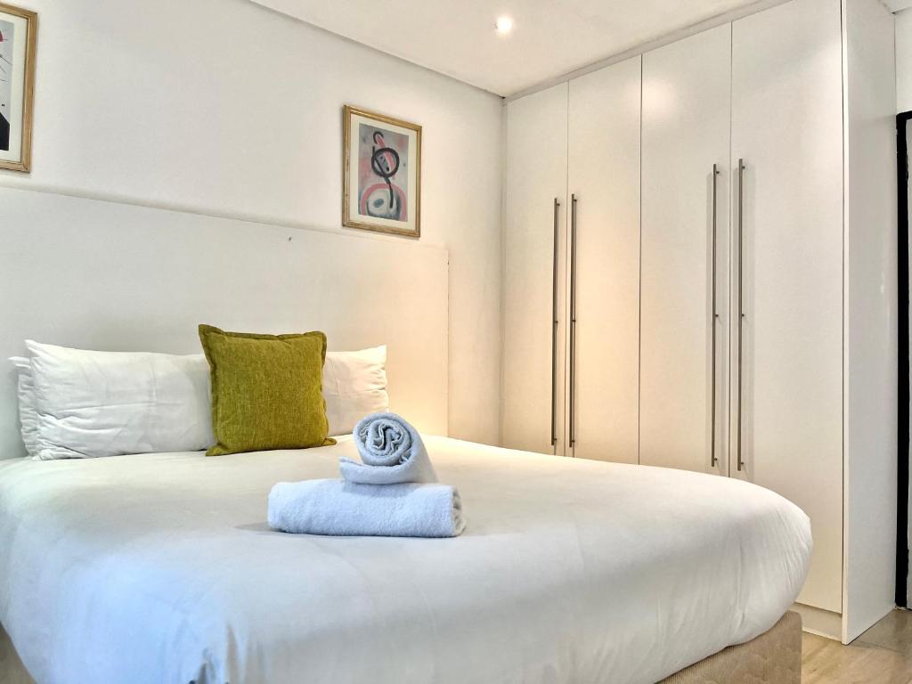 a bedroom with a white bed with a towel on it at No 6 On Cladon # Jadde Apartments in Chartwell
