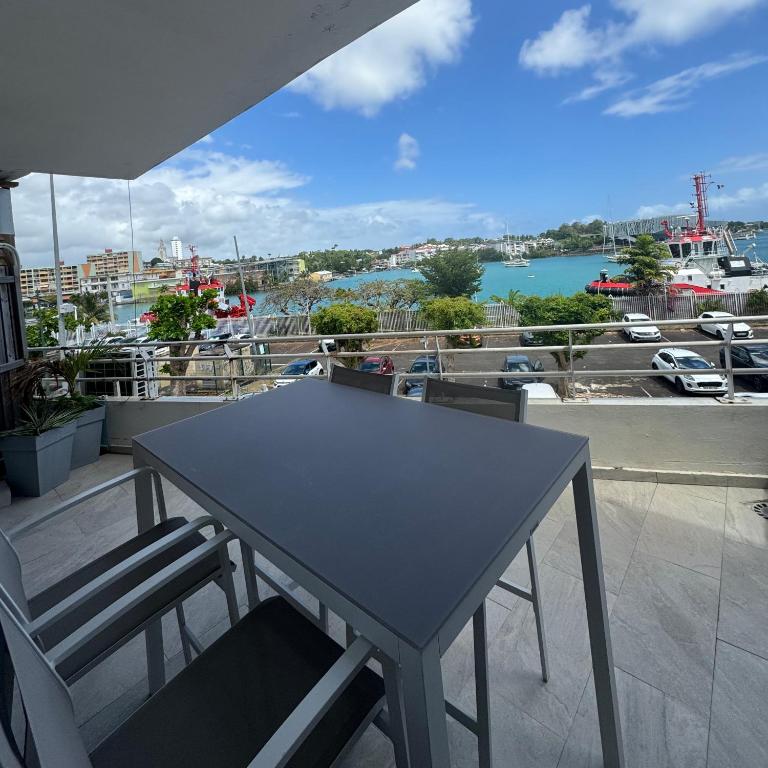 a table and chairs on a balcony with a view of a harbor at Le Loft in Pointe-à-Pitre