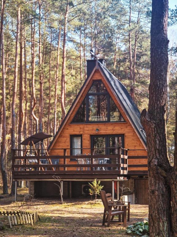 a log cabin in the woods with a tree at Leśna Chatka in Wola Polska