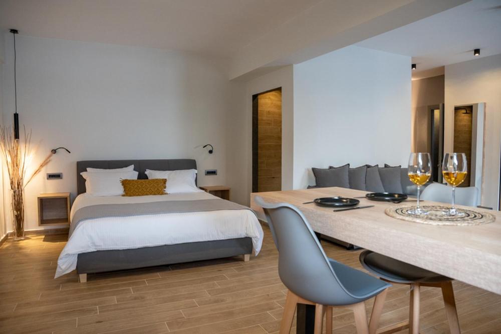 a bedroom with a bed and two glasses of wine at Τzegia Suites in Galissas