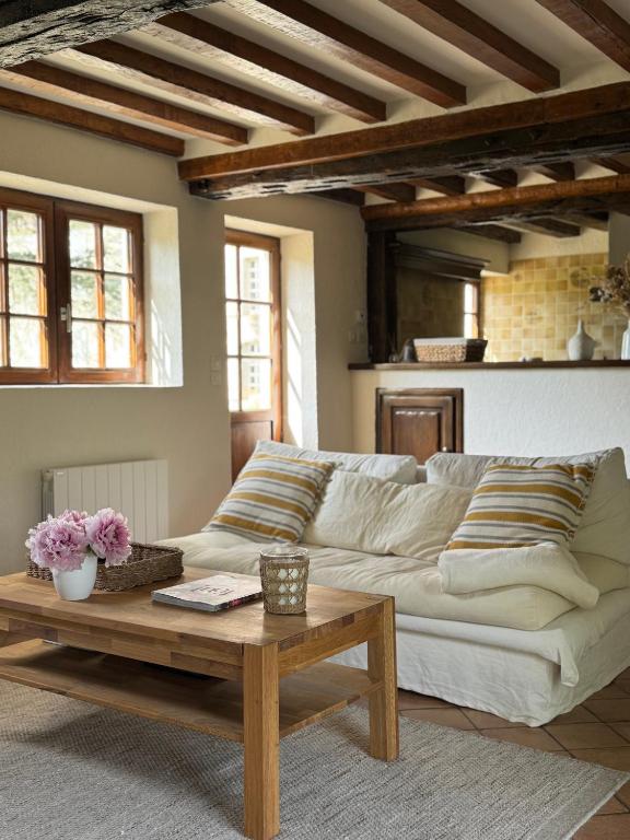 a living room with a white couch and a coffee table at La Cidrerie du Haras in Léaupartie