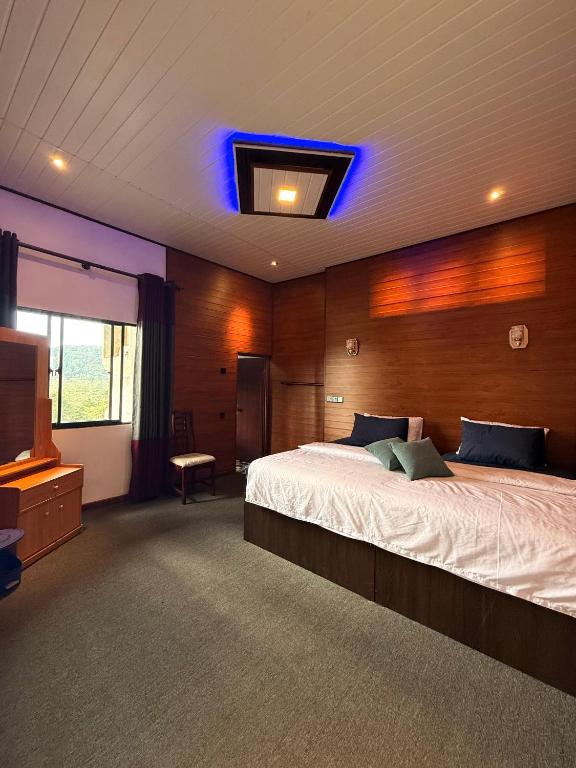 a bedroom with a large bed with a blue light at Roshan Guest House in Nuwara Eliya