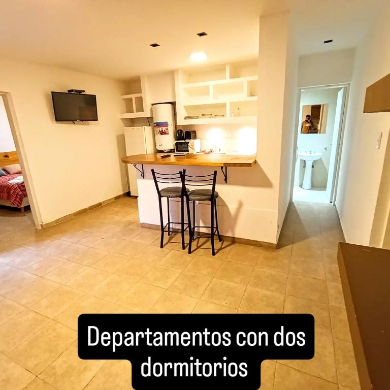 a kitchen with a counter and stools in a room at La Morenita dos dormitorios in Chilecito