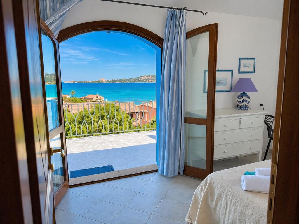 a bedroom with a door open to a view of the ocean at Villa Azzurra in Cannigione