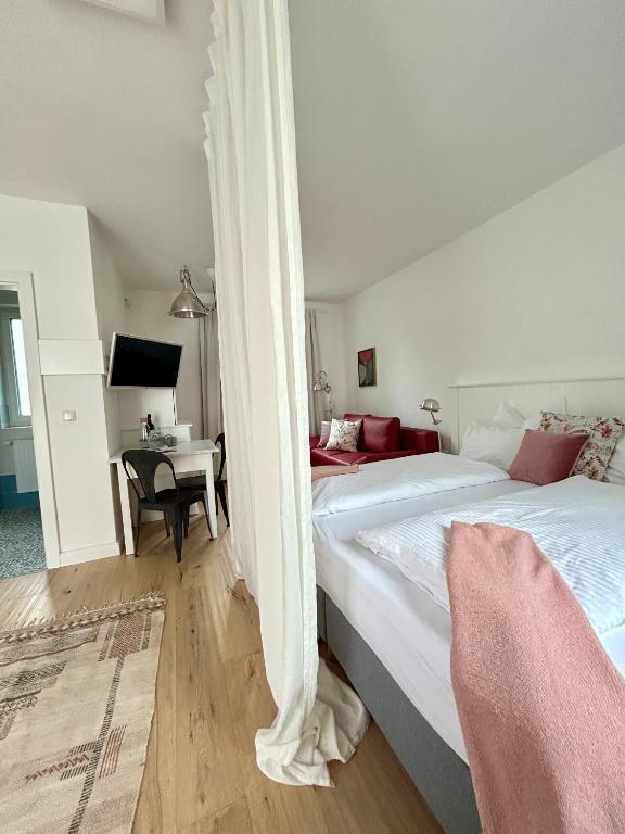 a bedroom with two beds and a desk with a piano at Domizil Gols, Studios Am Anger in Gols