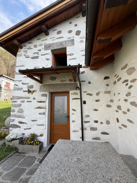 a stone building with a door and a window at Rustico Corte in Brissago