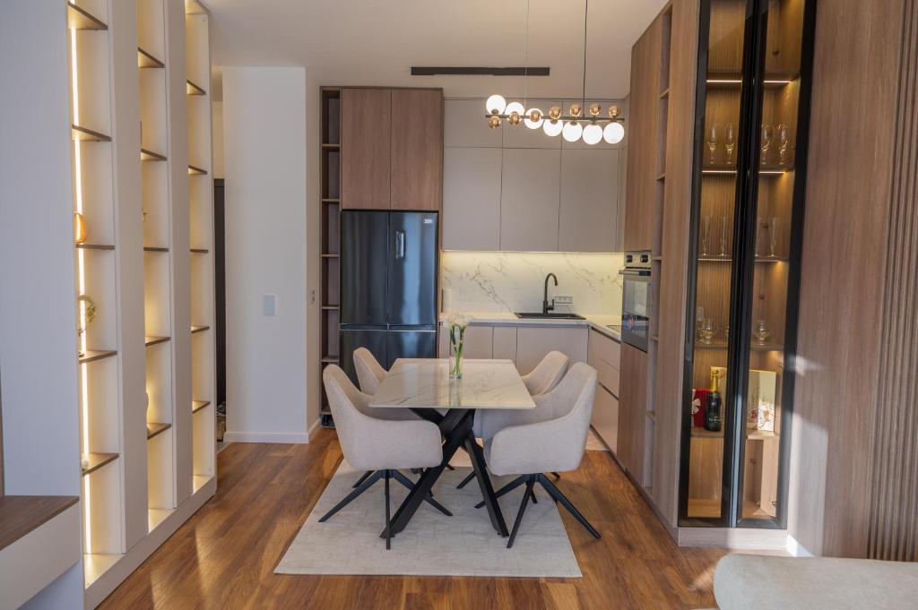 a kitchen with a table and some white chairs at Lux residence Adrijana 1 in Ulcinj