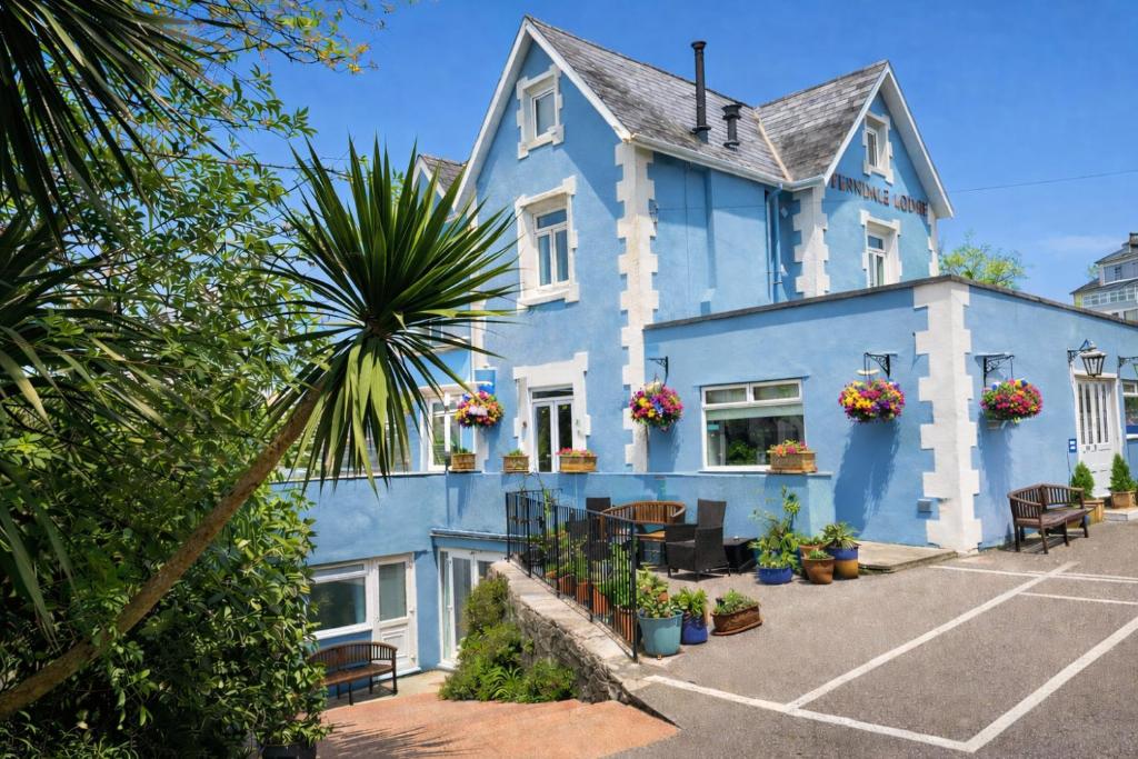 a blue building with plants in a parking lot at Ferndale Lodge in Torquay