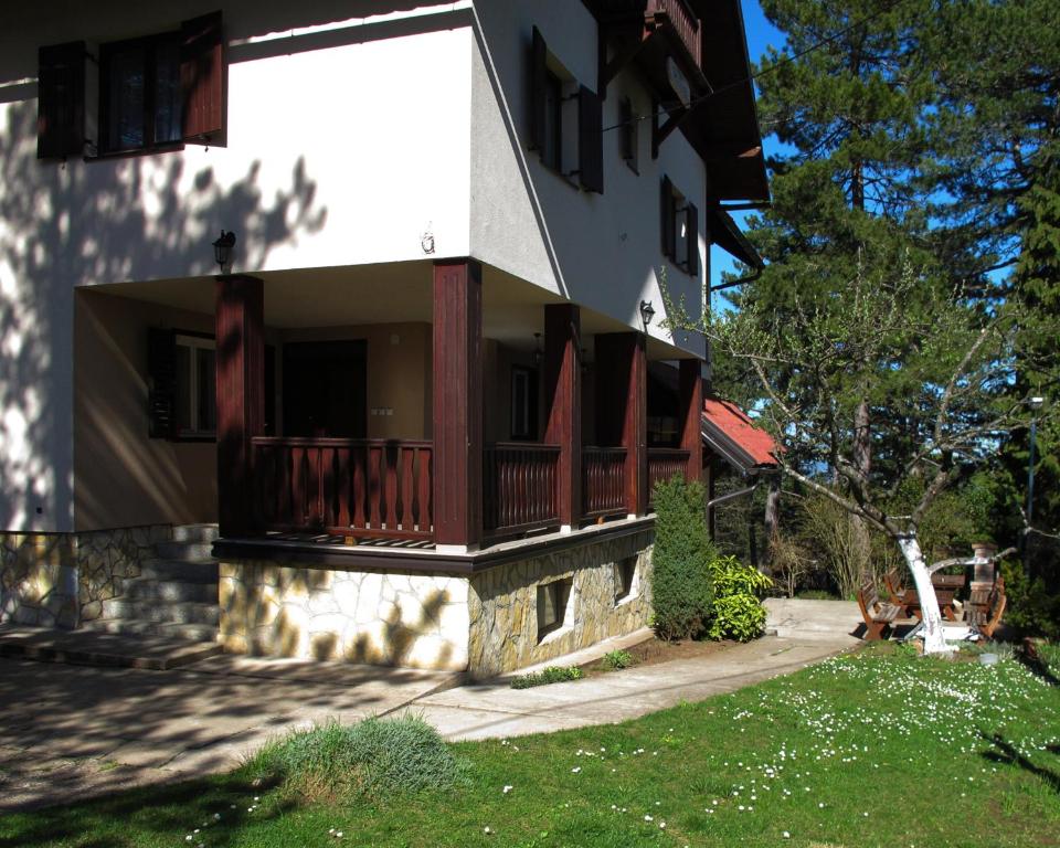 a house with a balcony and a yard at Tara3M Rooms and Apartments in Kaludjerske Bare