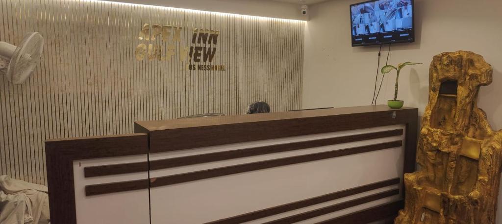 a reception desk in a room with a tv at Apex Inn Gulf View in Bangalore