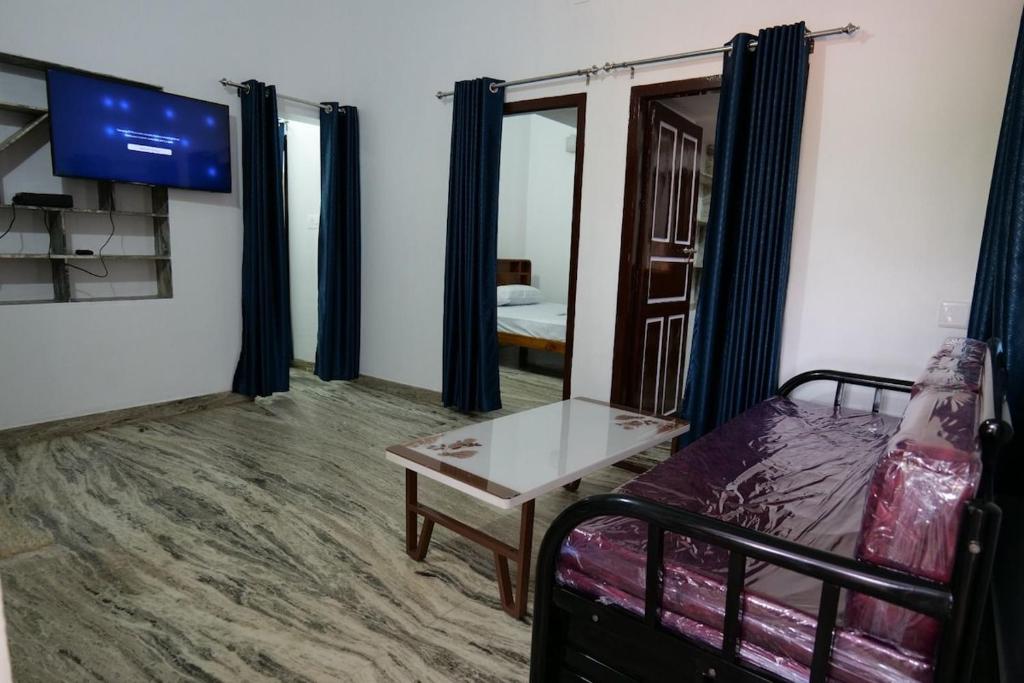 a room with a couch and a table and a tv at Velankanni Home Stay in Mangalore