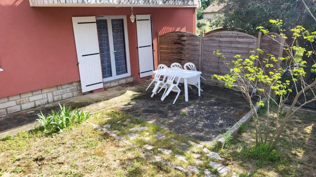 a table and chairs on the back of a house at L' Escale des Îles en rdc de villa avec jardin à 5mn des plages et de toutes les commodités in Six-Fours-les-Plages