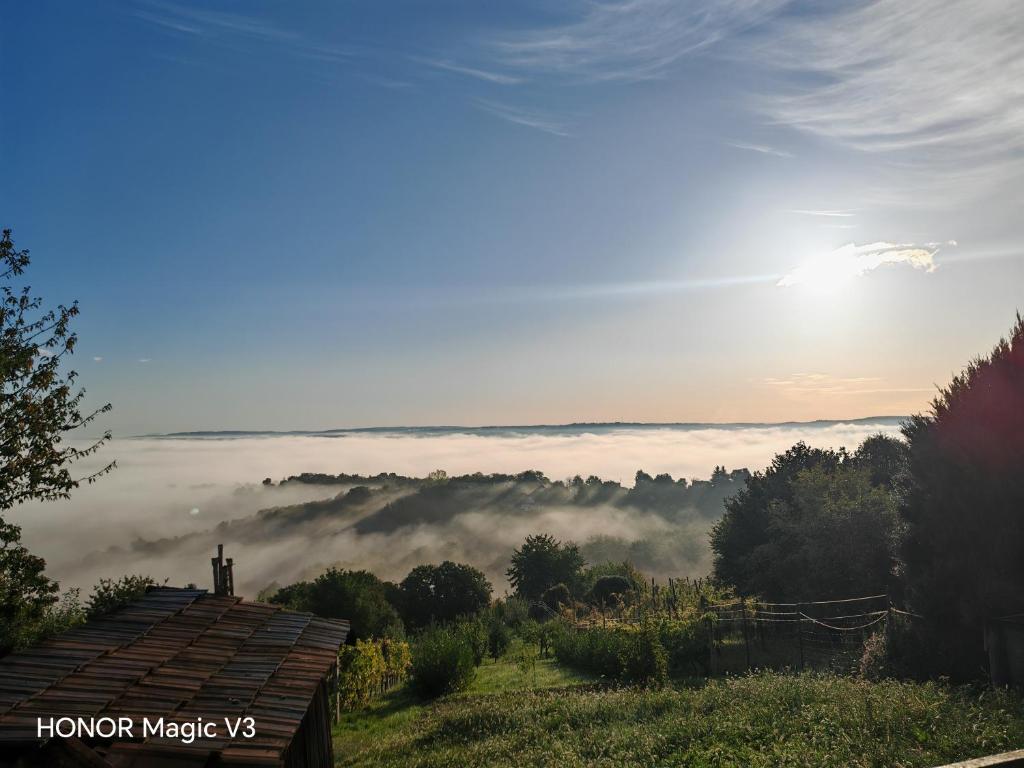 a view of a foggy valley with the sun in the background at Lacrima del Mare in Zalaegerszeg