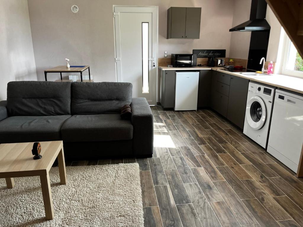 a living room with a couch and a kitchen at Fully equipped, independent apartment in Marles-en-Brie