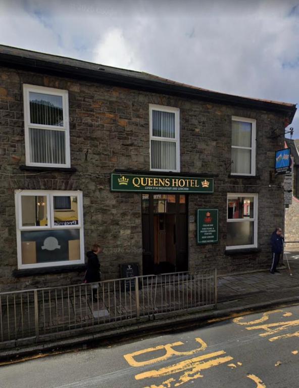 a brick building with a sign for a queens hotel at The Queens Hotel in Rhondda