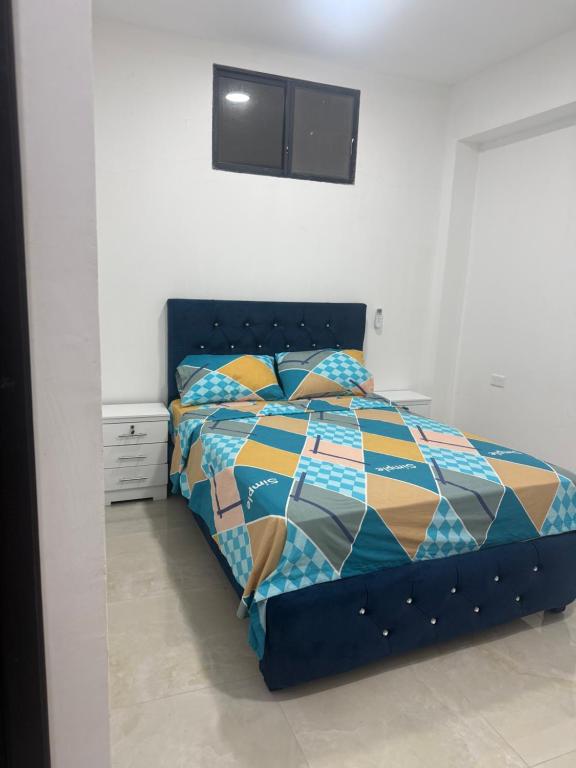 a bedroom with a bed with a colorful comforter at Habitaciones de alquiler in La Libertad