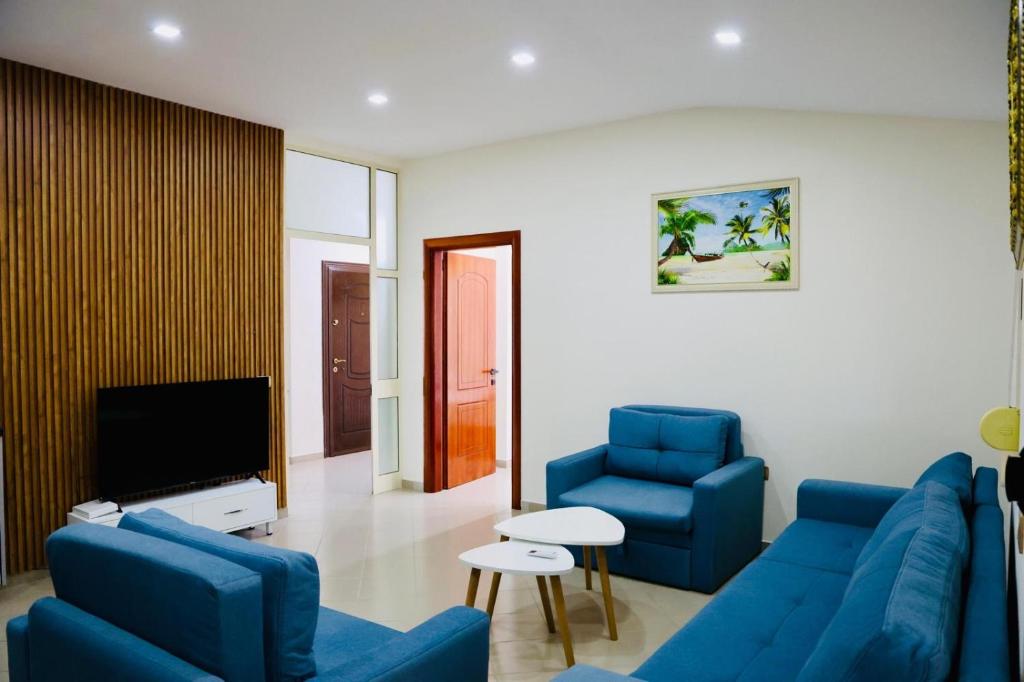 a living room with blue couches and a tv at Gees House in Golem