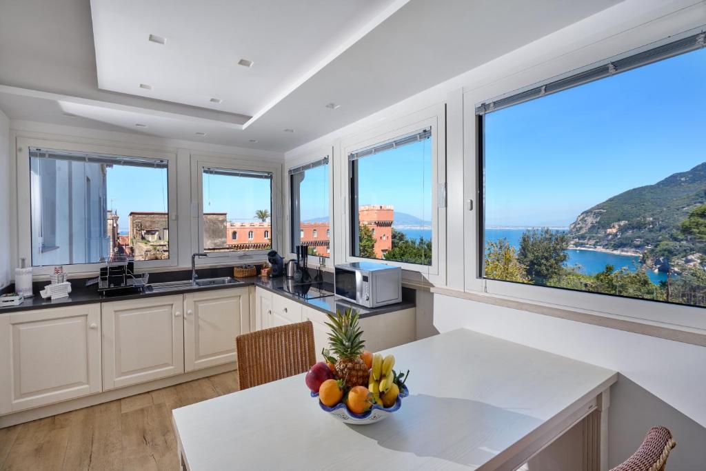 a kitchen with a table with a bowl of fruit on it at Mary’s Guest House in Vico Equense