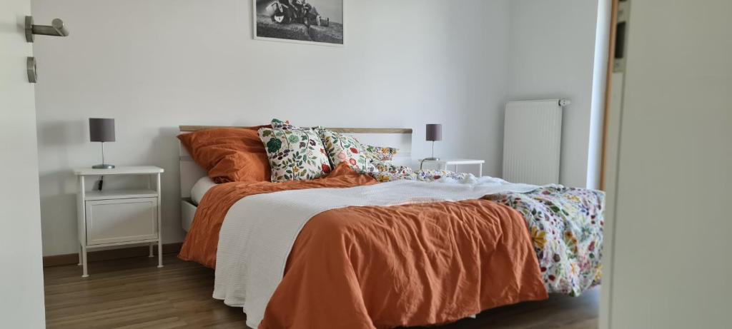 a bedroom with a bed with an orange comforter at Spessartblick Eisingen in Eisingen