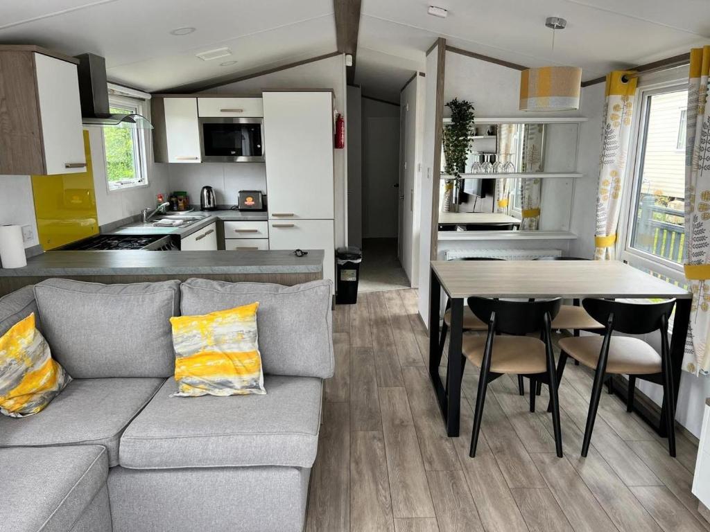 a living room and kitchen with a couch and a table at 820 Ocean View, Lydstep Haven Beach in Tenby
