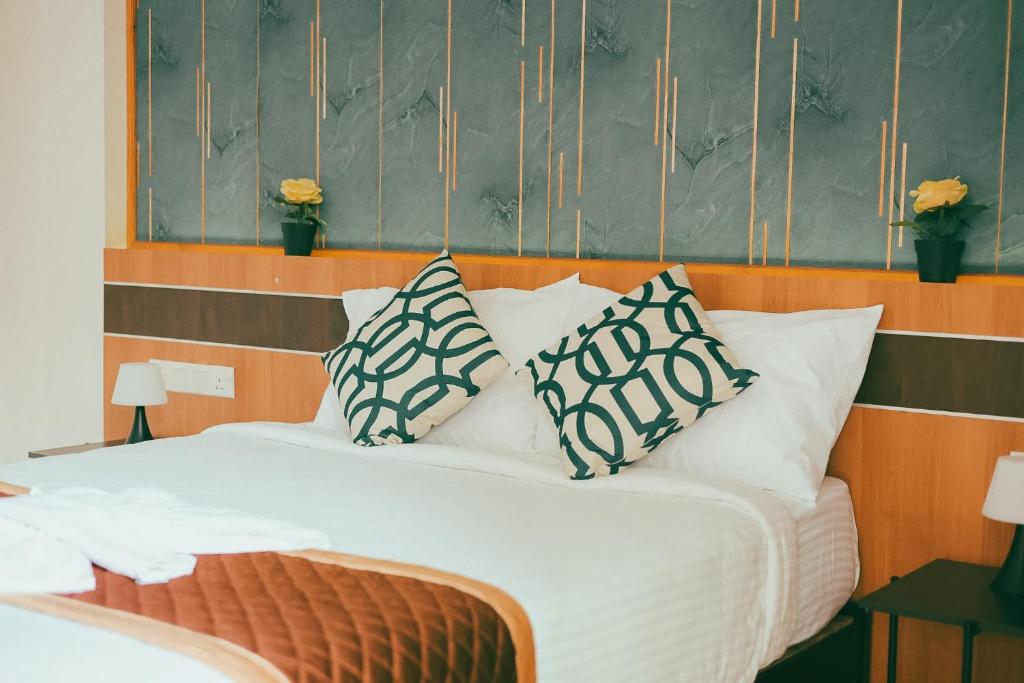 a bed with pillows on it in a room at The R One in Male City