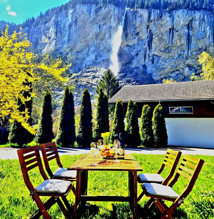 a table and chairs with a mountain in the background at Chalet Bellevue Beautiful Waterfall view private Garden & free parking in Lauterbrunnen