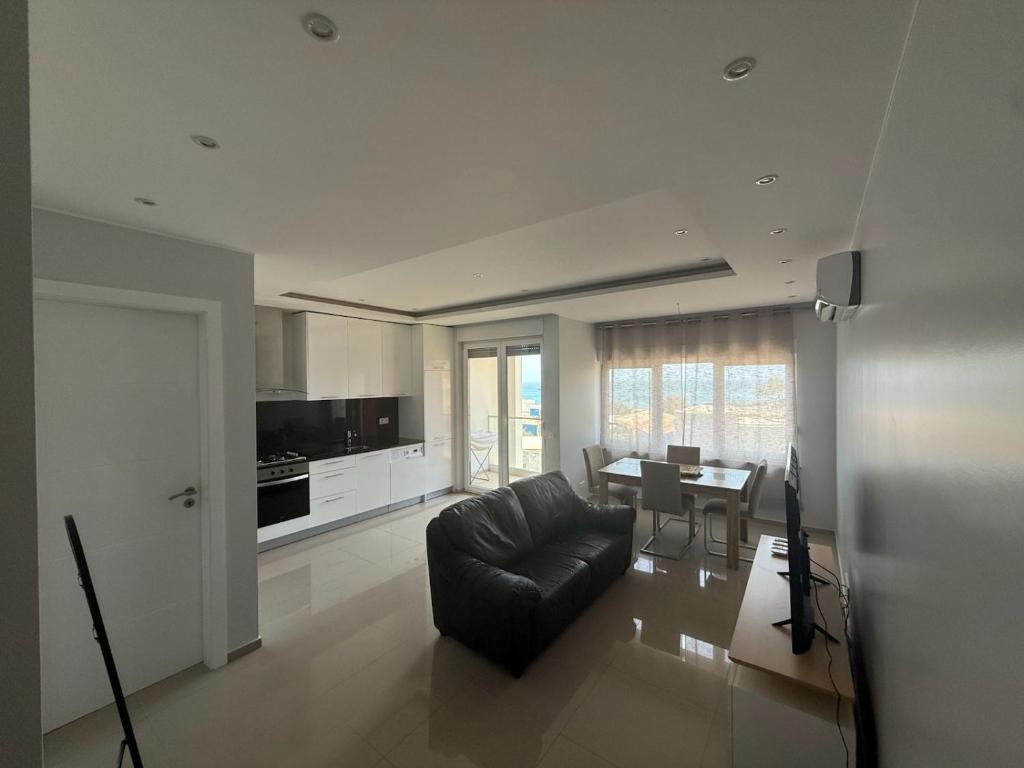 a living room with a black couch and a table at Miles Dreams Laginha in Mindelo