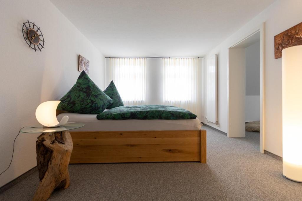 a bedroom with a bed with green sheets and a window at Kerstins Lieblingsdomizil in Oelsnitz