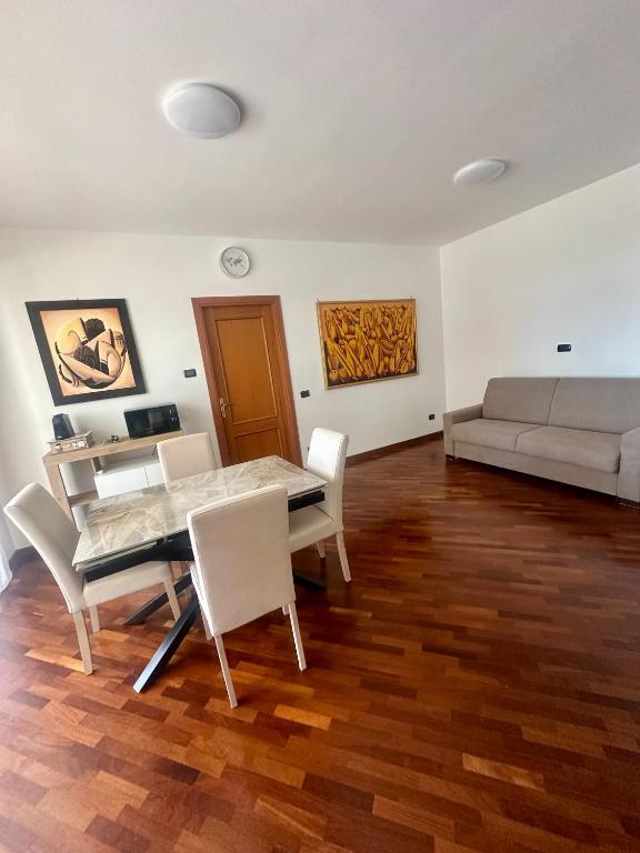 a living room with a table and chairs and a couch at Domus Leonardo Apartment in Fiumicino Airport