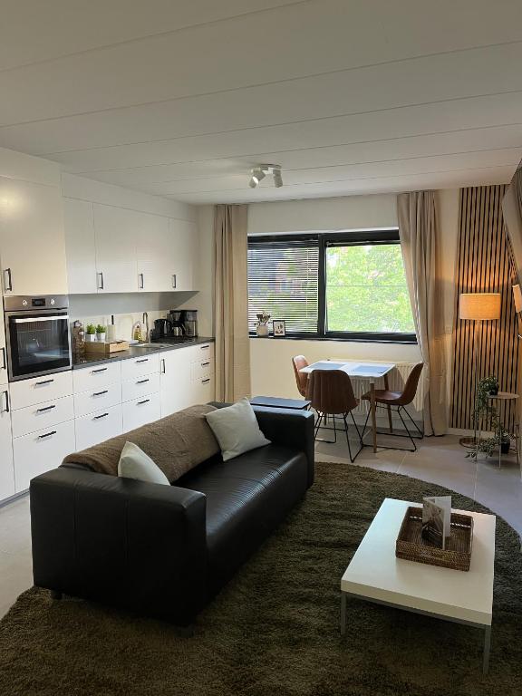 a living room with a black couch and a table at Business Accommodation 'Comfort Living' in Geel