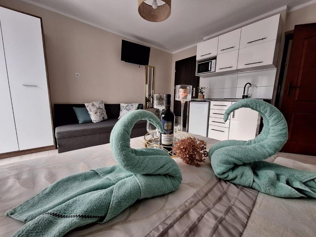 a living room with two green swans on the floor at Willa Jarmar - sala kominkowa z bilardem, wewnętrzny oraz zewnętrzny plac zabaw in Brenna