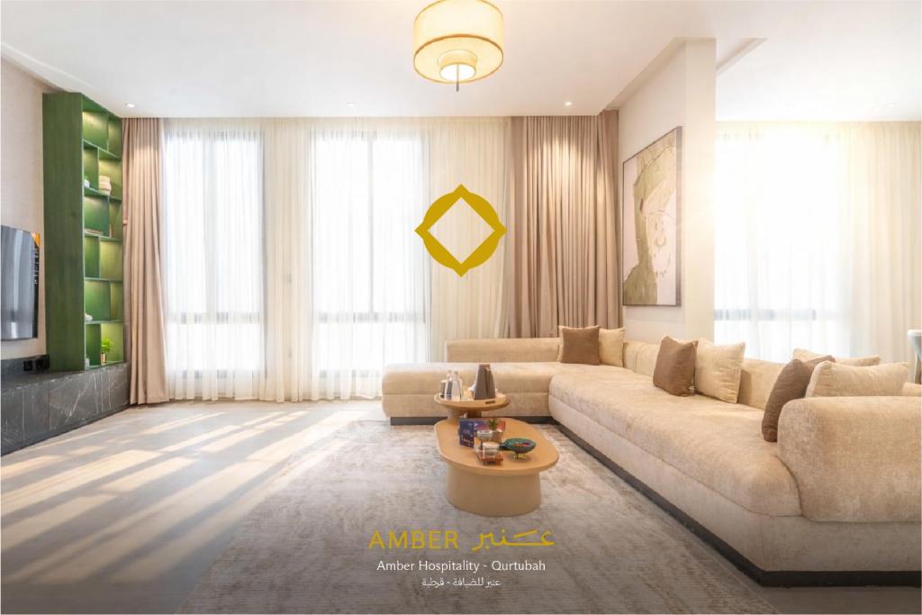un soggiorno con un divano e un tavolo di Amber Hospitality - Qurtubah a Riyad
